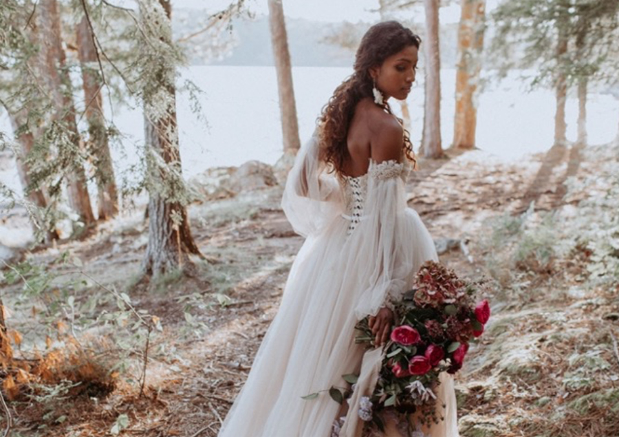 Whimsical bride walking through forest.